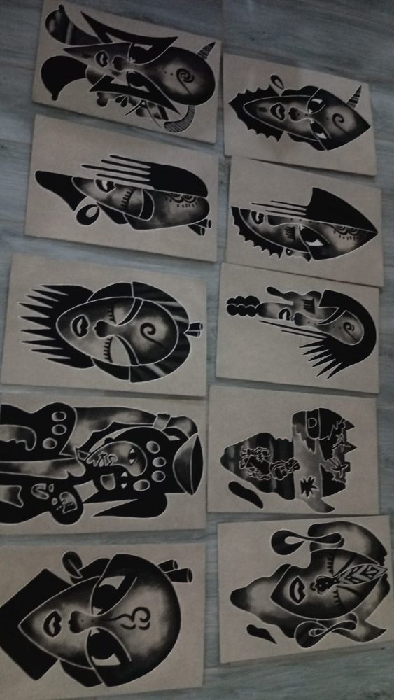 A series of bold black-ink mask drawings